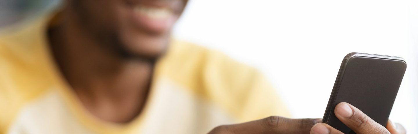 Closeup of modern smartphone in african american guy hands