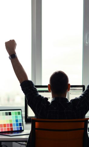 Victorious man celebrating his success in his work place