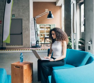 young businesswoman working and sitting with laptop in modern office